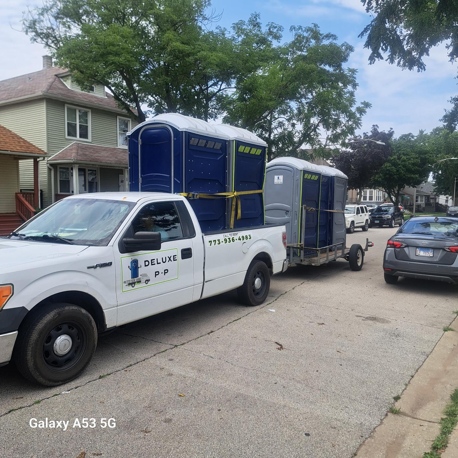 Deluxe P-P Services delivery truck with portable restrooms on a Chicago residential street